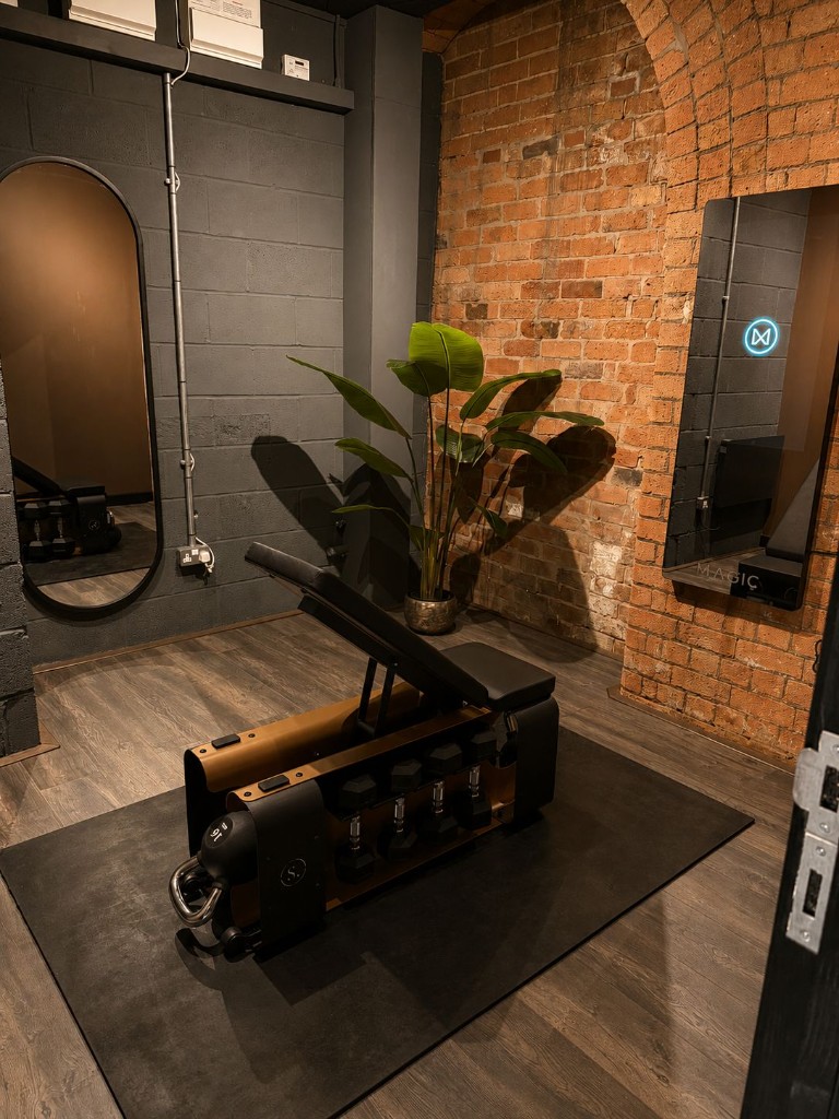 Private grip.pod training space with smart mirror and strength equipment